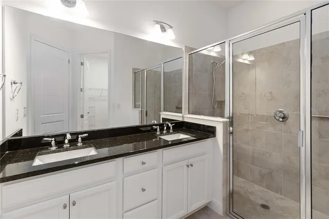 a bathroom with double sink and a mirror