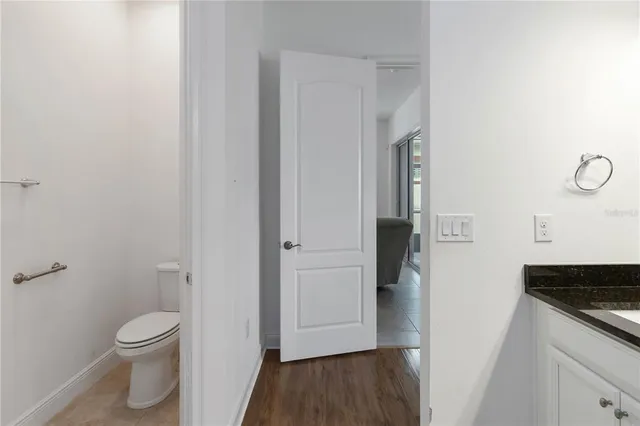 a bathroom with a granite countertop toilet and a sink