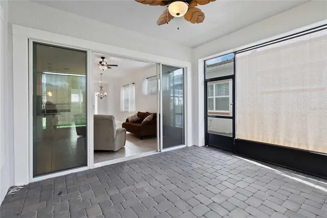 a view of a livingroom with a chandelier fan and windows