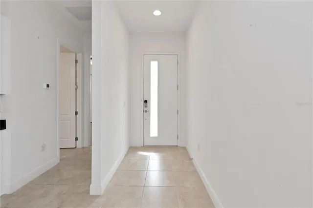 a view of a hallway with wooden floor and a bathroom