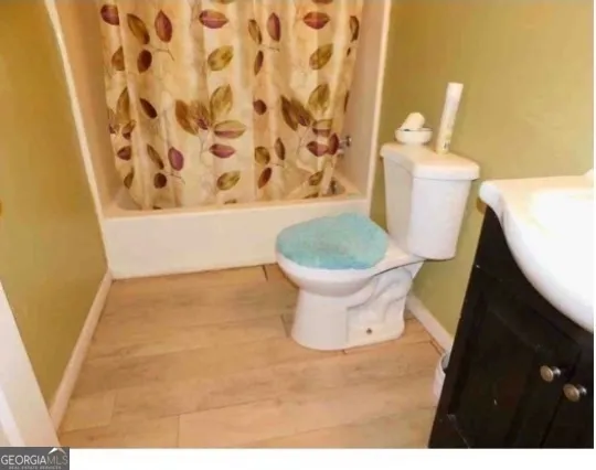 a white toilet sitting next to a shower curtain