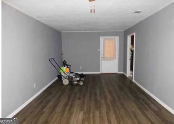 a view of a room with wooden floor and bench