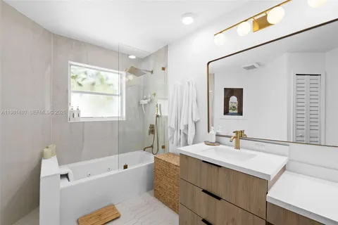 a bathroom with a sink mirror vanity bathtub and a toilet