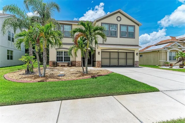 a front view of a house with a yard and potted plants