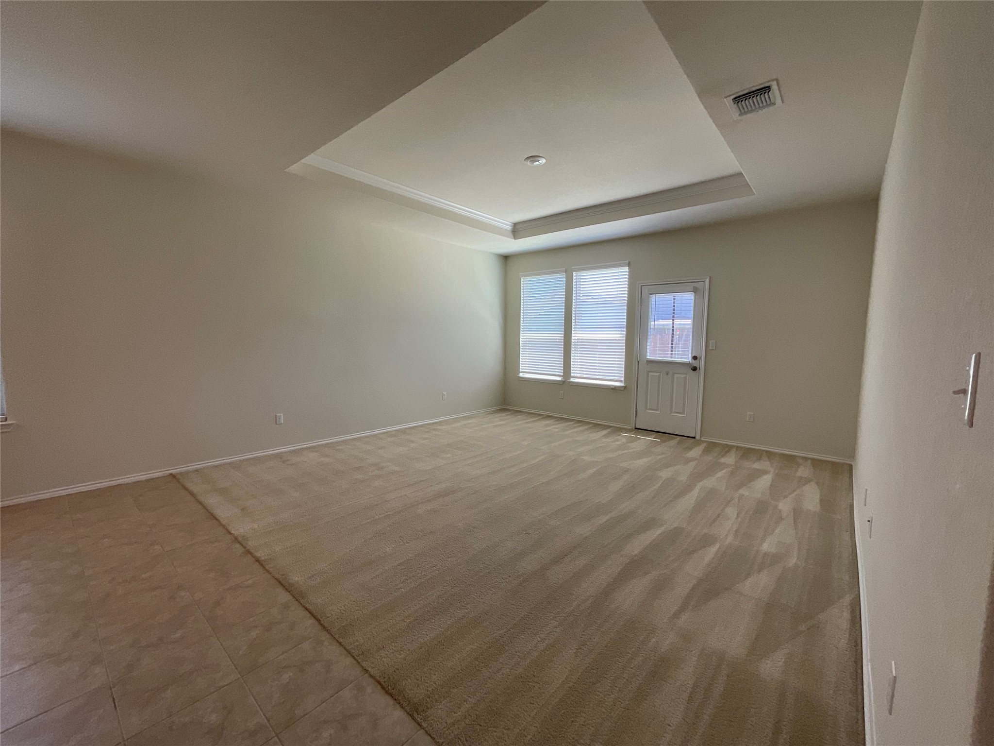 3451 Mayfield Ranch Boulevard, Unit 311 Round Rock, TX 78681 - Photo 14 of 29 Empty room with a raised ceiling and light colored carpet