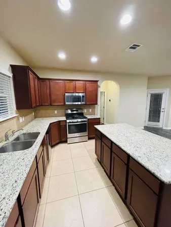 a kitchen with stainless steel appliances granite countertop a refrigerator stove microwave and sink