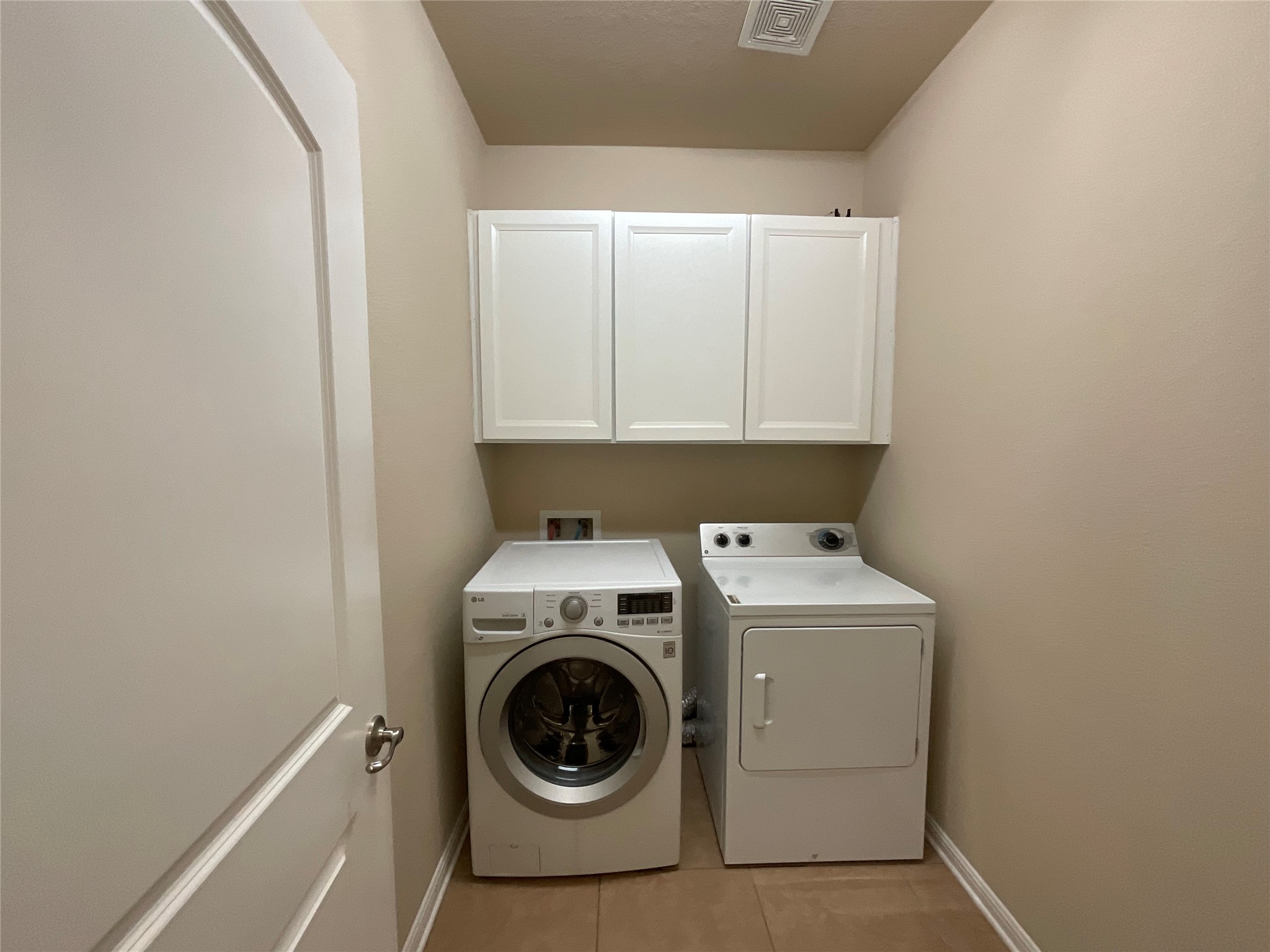 3451 Mayfield Ranch Boulevard, Unit 311 Round Rock, TX 78681 - Photo 20 of 29 Laundry room featuring cabinet space, separate washer and dryer, and light tile patterned flooring