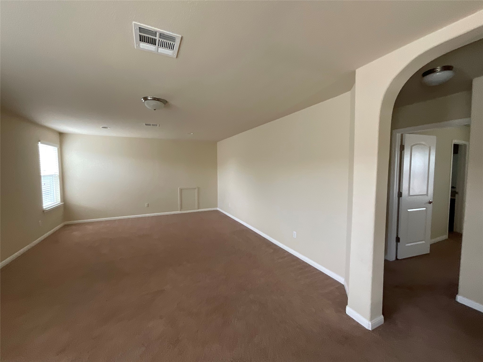 3451 Mayfield Ranch Boulevard, Unit 311 Round Rock, TX 78681 - Photo 21 of 29 Empty room featuring arched walkways and dark colored carpet