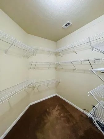 a view of an empty room with a chandelier fan