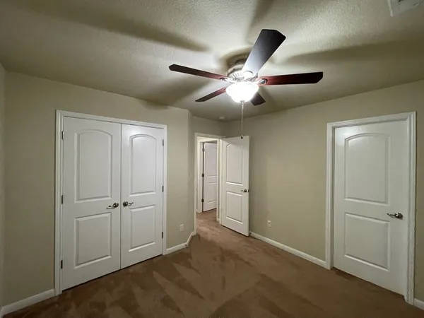 an empty room with a bathroom and a window