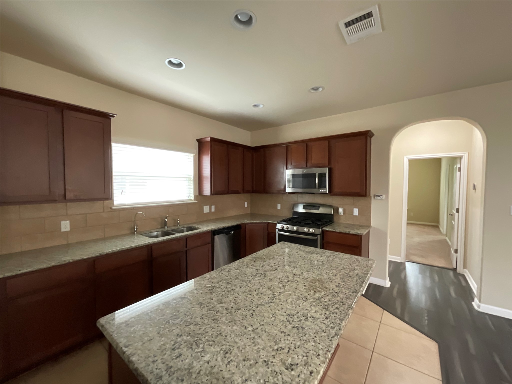 3451 Mayfield Ranch Boulevard, Unit 311 Round Rock, TX 78681 - Photo 7 of 29 Kitchen featuring stainless steel appliances, decorative backsplash, light stone counters, and recessed lighting