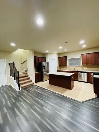 a kitchen with stainless steel appliances granite countertop a sink stove microwave refrigerator and cabinets