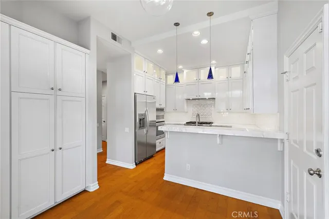 a kitchen with stainless steel appliances kitchen island granite countertop a refrigerator and a sink