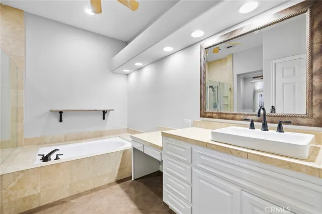 a bathroom with a tub sink and mirror