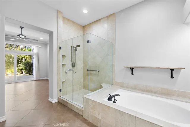 a bathroom with a tub shower and window
