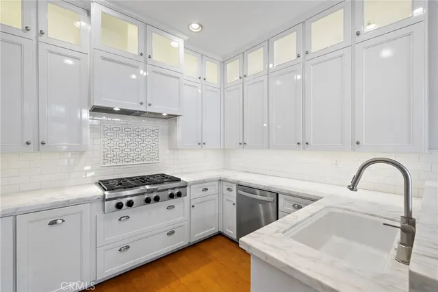 a kitchen with granite countertop a sink a stove and cabinets