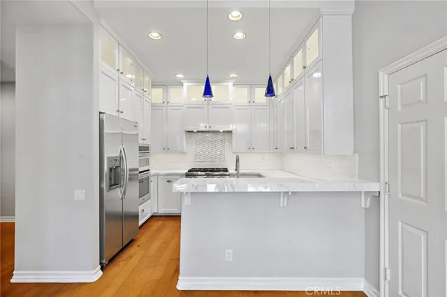 a kitchen with stainless steel appliances granite countertop a sink a stove and a refrigerator