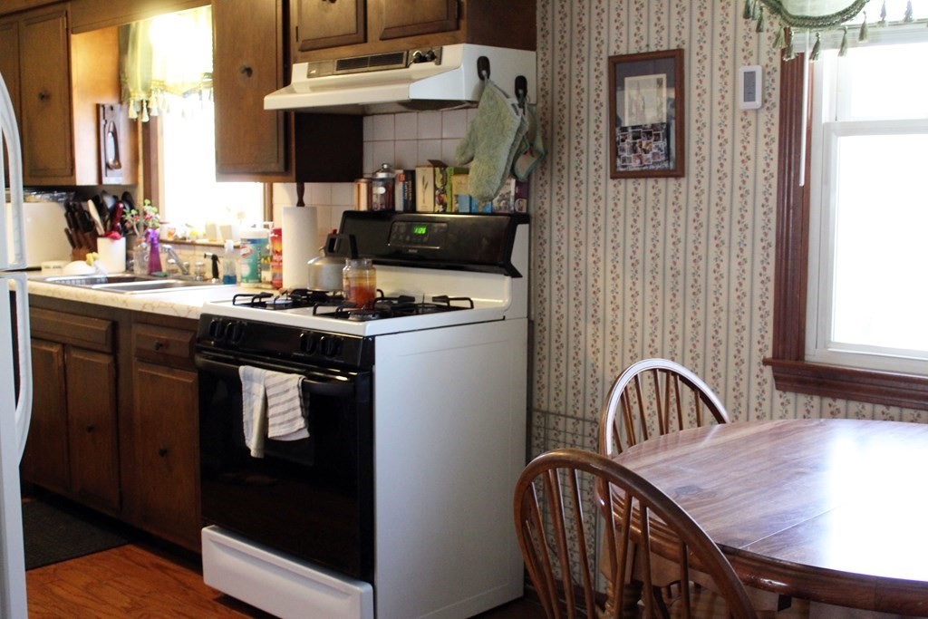 48 Bexhill Street Springfield, MA 01119 - Photo 13 of 14 a kitchen with a table chairs sink and cabinets