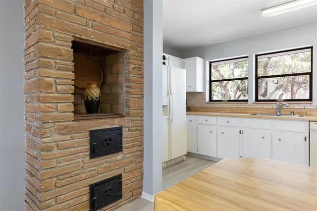 a bathroom with a granite countertop toilet a sink and a window