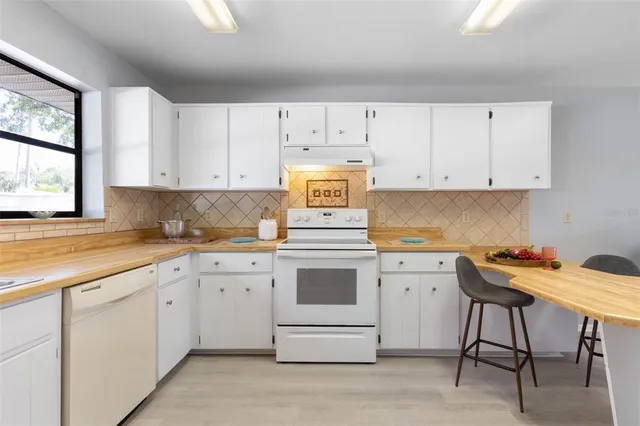 a view of a house with a yard and palm tree