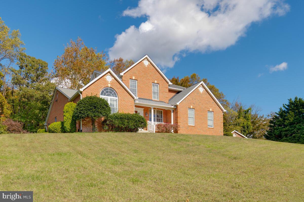 a front view of house with yard and trees around