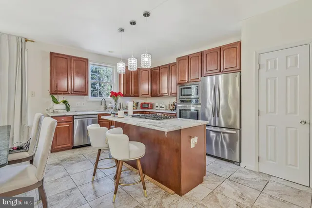 a kitchen with stainless steel appliances granite countertop a refrigerator a stove a sink and a refrigerator