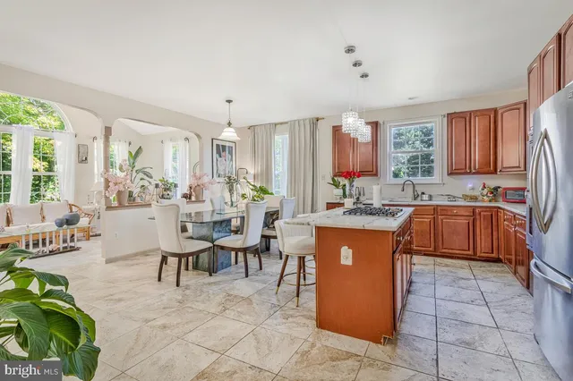 a kitchen with a sink a counter top space and living room view