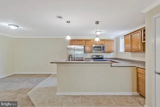 a view of kitchen with refrigerator cabinets and window