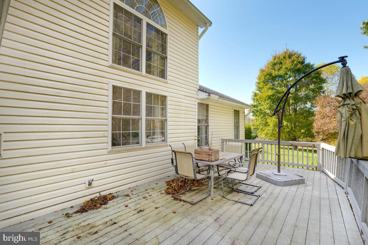 215 Hoile Lane Huntingtown, MD 20639 - Photo 50 of 52 a view of a deck with table and chairs and wooden floor