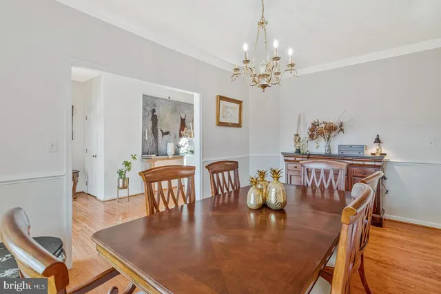 a view of a dining room with furniture a chandelier and wooden floor