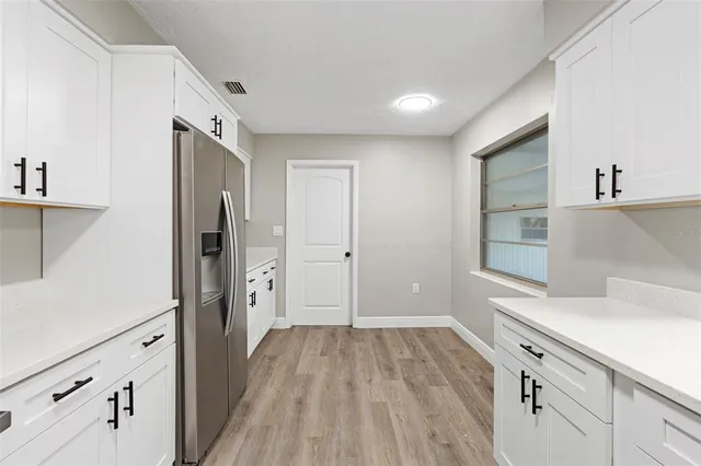 a view of a kitchen with wooden floor and electronic appliances
