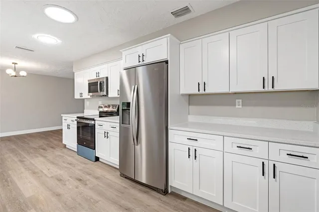 a kitchen with cabinets stainless steel appliances and a counter space