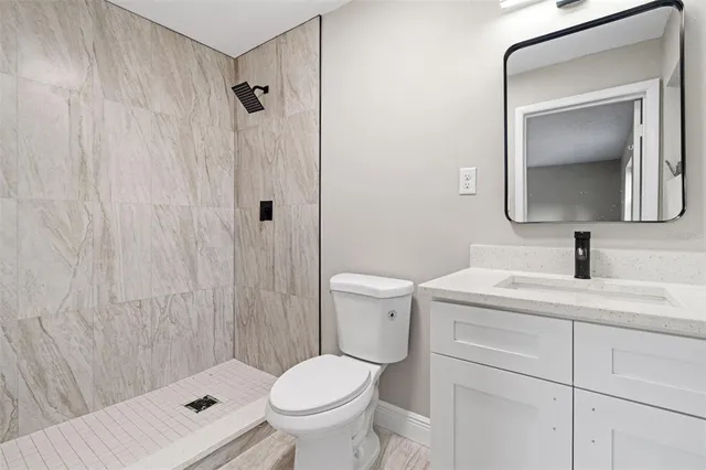 a bathroom with a toilet sink vanity and mirror
