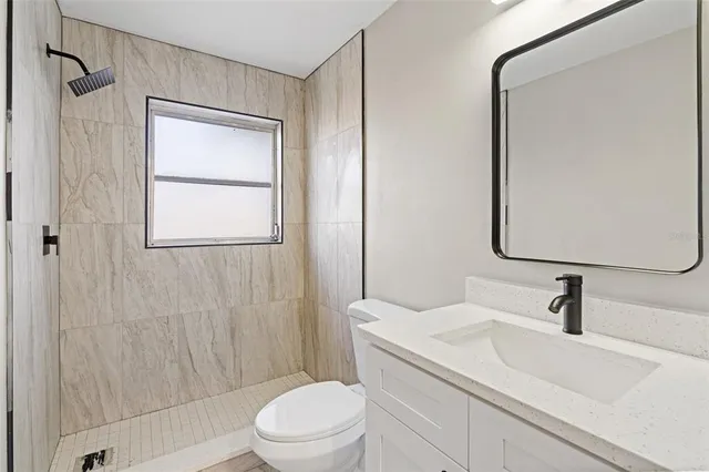 a bathroom with a sink a toilet and shower