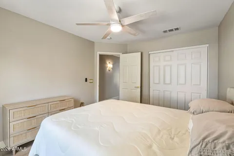 a bedroom with a bed and a ceiling fan