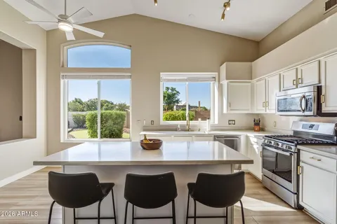 a kitchen with stainless steel appliances a stove a table and chairs in it