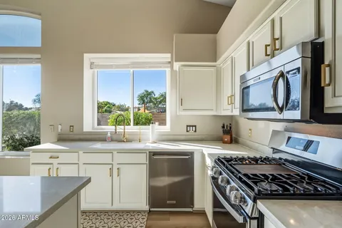 a kitchen with stainless steel appliances granite countertop a stove a sink and a microwave