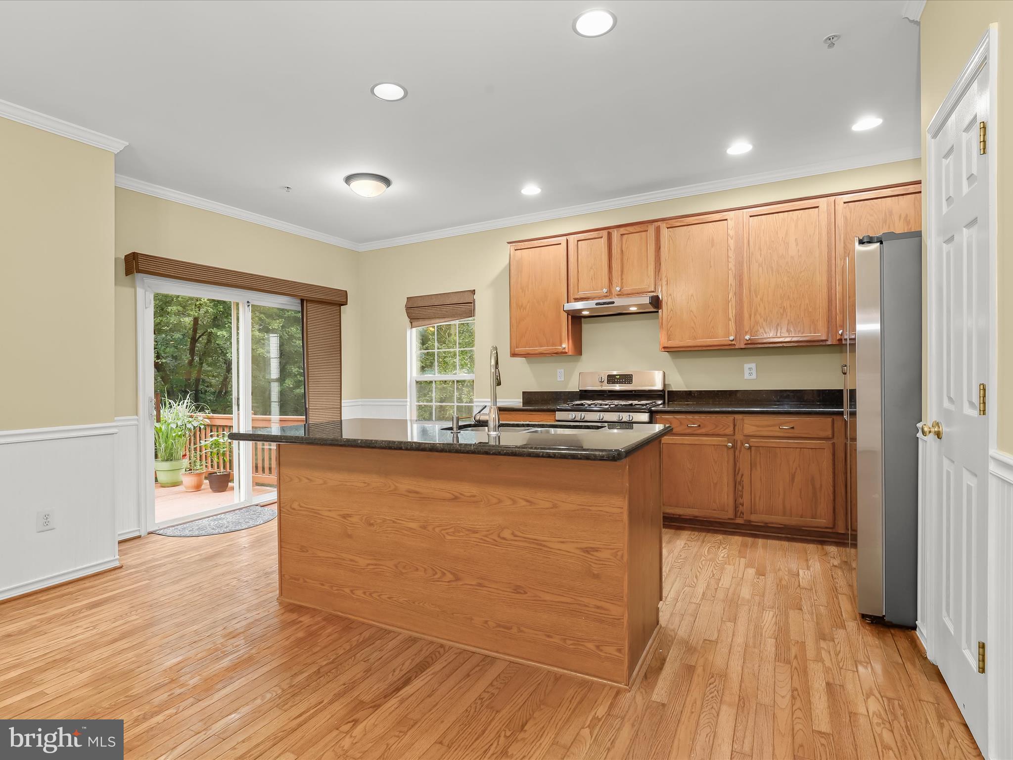 2614 Streamview Drive Odenton, MD 21113 - Photo 8 of 52 a kitchen with stainless steel appliances granite countertop a stove a sink and a refrigerator with wooden floor