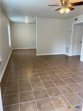 an empty room with a bathroom and a mirror