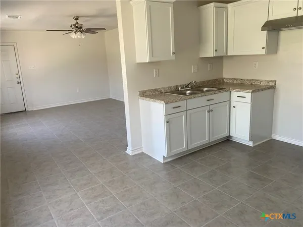 a kitchen with white cabinets and white appliances