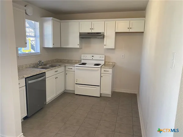 a kitchen with a stove sink and cabinets
