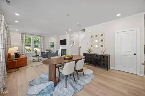 a kitchen with stainless steel appliances a dining table chairs stove refrigerator and cabinets