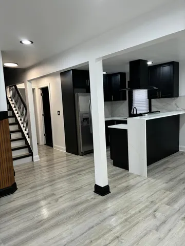 a view of a living room with wooden floor and stairs