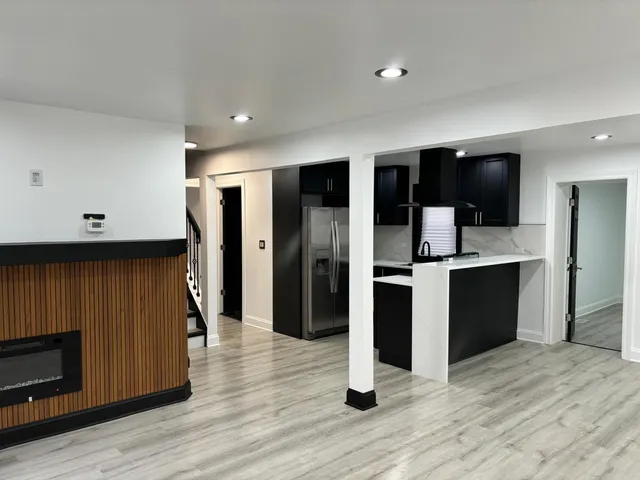 a kitchen with stainless steel appliances kitchen island granite countertop a refrigerator and a stove top oven