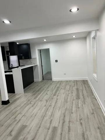 a view of a living room with wooden floor and a sink