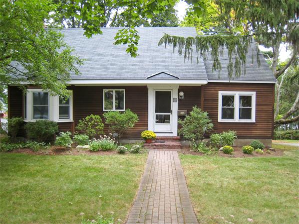 a front view of a house with a yard and potted plants