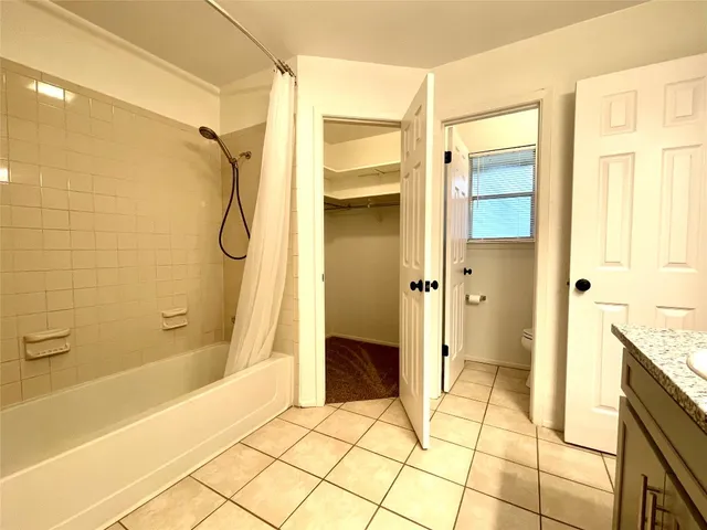 a view of an empty room and window and chandelier fan