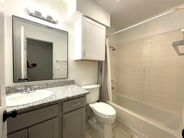 a view of a livingroom with a refrigerator a ceiling fan and wooden floor