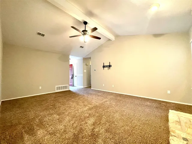 a view of an empty room with a fireplace and a window