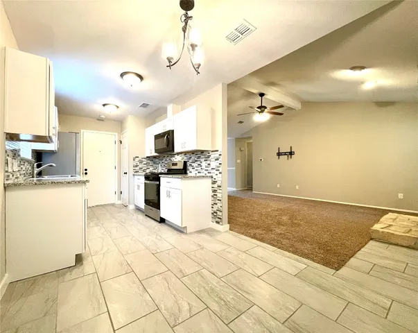 a kitchen with stainless steel appliances granite countertop a stove microwave and oven